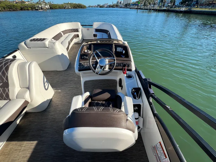  Yacht Photos Pics 2021 Bennington 27 QX boat interior with steering wheel, seating, and water view.