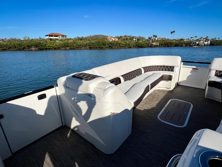  Yacht Photos Pics Luxurious seating on a 2021 Bennington 27 QX boat, overlooking serene waters.