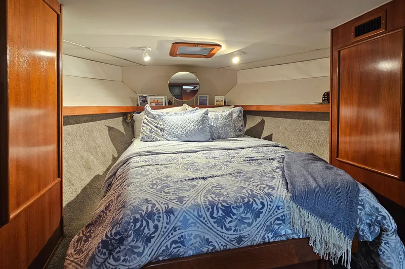 Tizzylizzy Yacht Photos Pics Cozy bedroom in 1989 Post 43 Convertible yacht with elegant bedding and wooden cabinetry.
