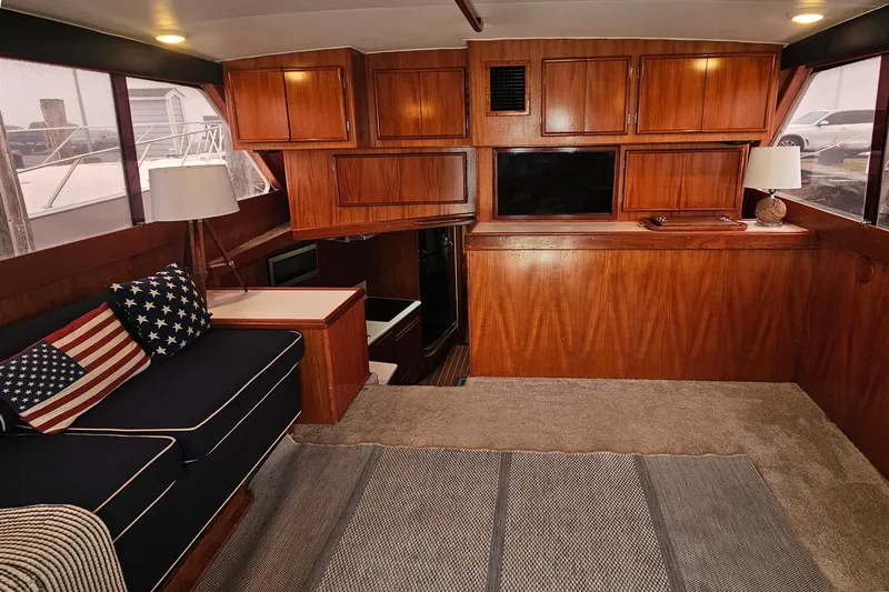 Tizzylizzy Yacht Photos Pics Interior of a 1989 Post 43 Convertible yacht with wooden cabinetry and cozy seating.