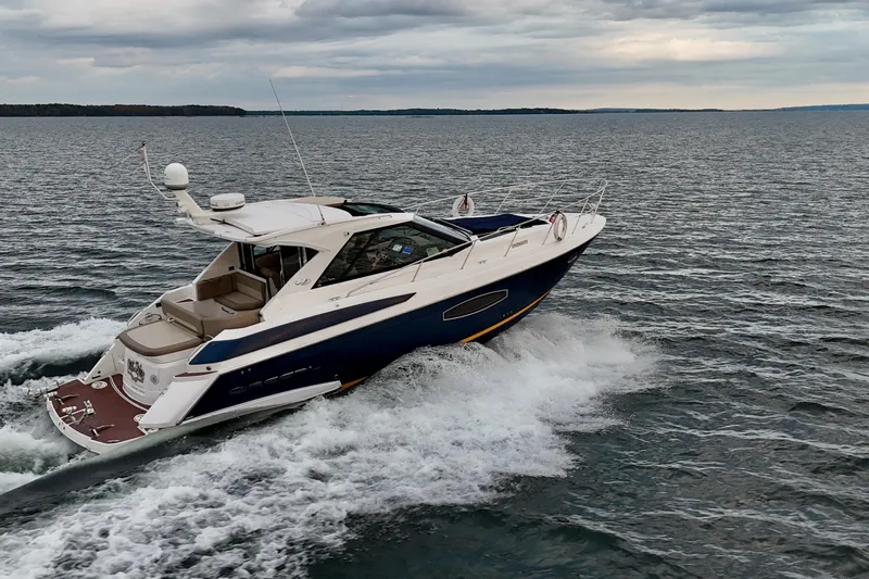 Knot Seine Yacht Photos Pics 2013 Regal 42 Sport Coupe cruising on open water under cloudy skies.