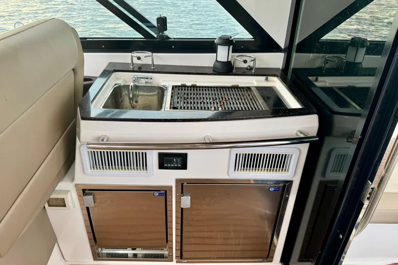 Knot Seine Yacht Photos Pics 2013 Regal 42 Sport Coupe yacht kitchenette with sink, grill, and storage.