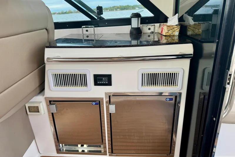 Knot Seine Yacht Photos Pics 2013 Regal 42 Sport Coupe interior with kitchenette, featuring stainless steel appliances and countertop.