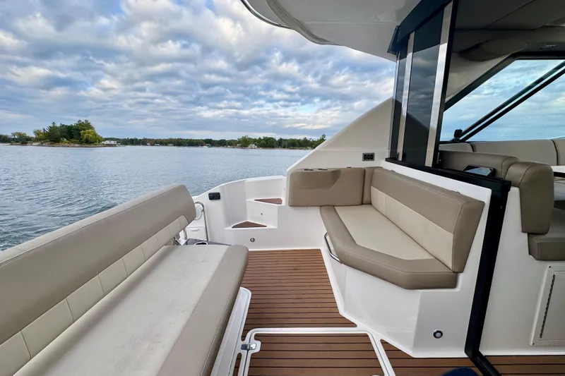 Knot Seine Yacht Photos Pics 2013 Regal 42 Sport Coupe boat interior with seating, overlooking calm waters and cloudy sky.