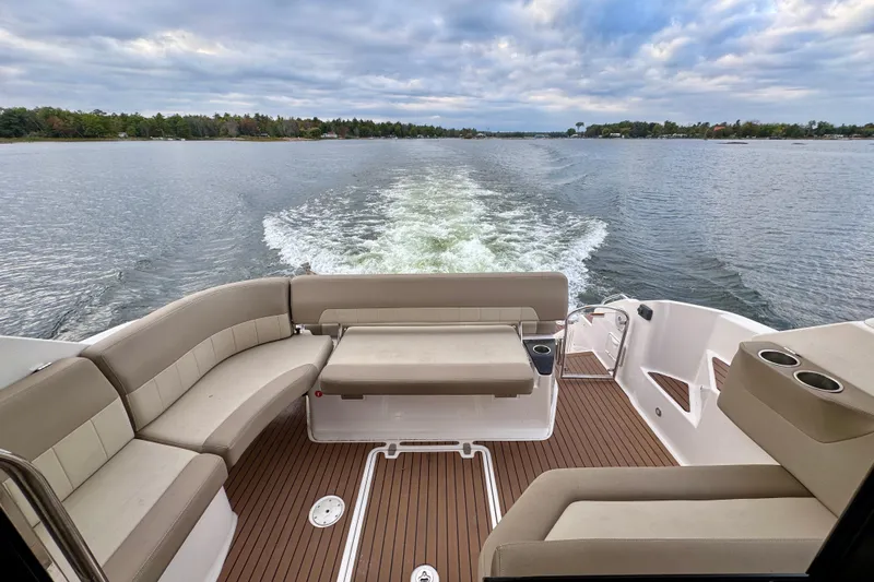 Knot Seine Yacht Photos Pics Rear view of 2013 Regal 42 Sport Coupe on a lake, featuring spacious seating.
