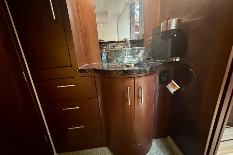 Knot Seine Yacht Photos Pics Luxurious bathroom interior of 2013 Regal 42 Sport Coupe with glass sink and wooden cabinetry.