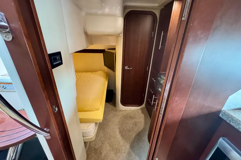 Knot Seine Yacht Photos Pics 2013 Regal 42 Sport Coupe cabin interior with cozy bed and wooden cabinetry.