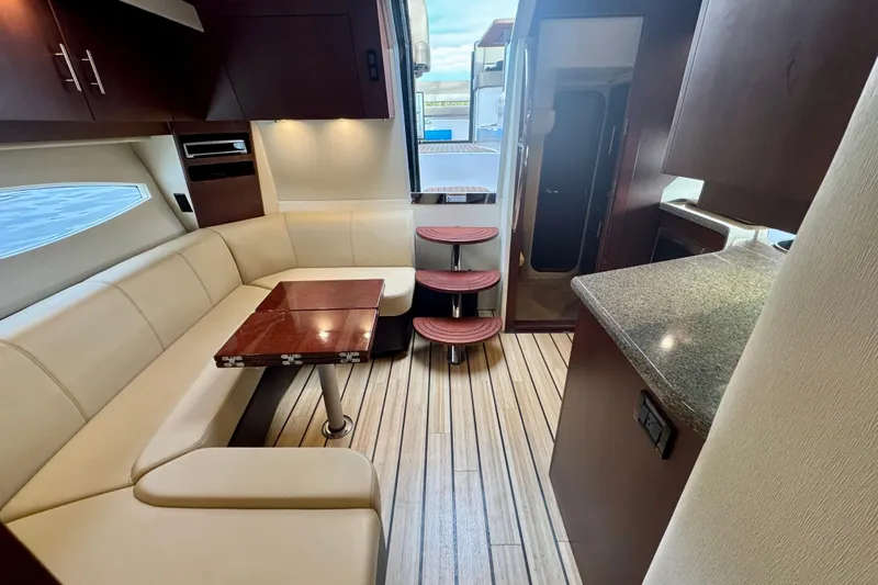 Knot Seine Yacht Photos Pics Interior of 2013 Regal 42 Sport Coupe with beige seating and wooden accents.