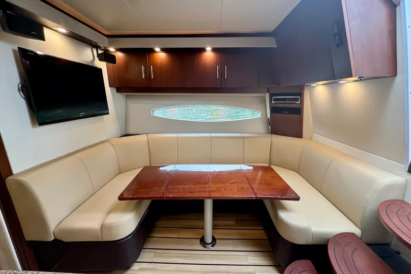 Knot Seine Yacht Photos Pics Luxurious interior of 2013 Regal 42 Sport Coupe with leather seating and wooden table.