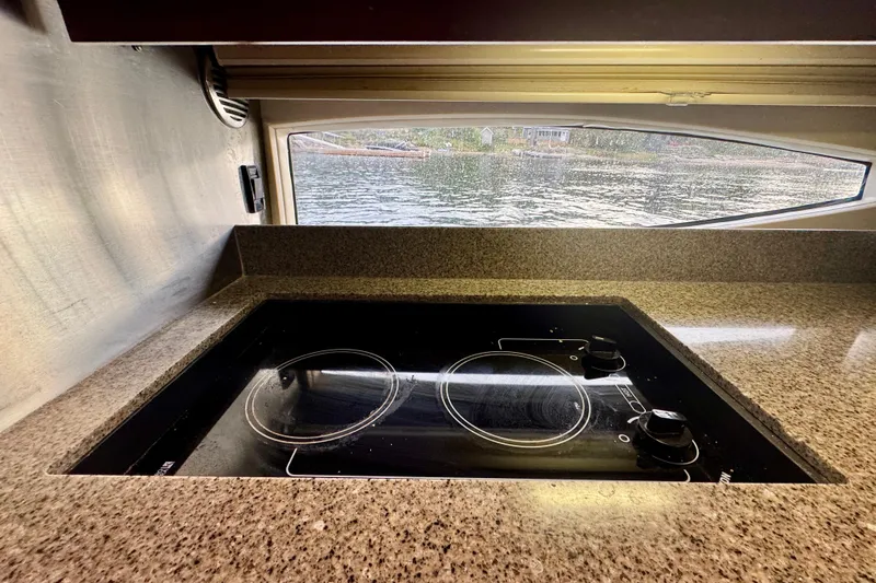 Knot Seine Yacht Photos Pics Stovetop in 2013 Regal 42 Sport Coupe yacht kitchen with water view.