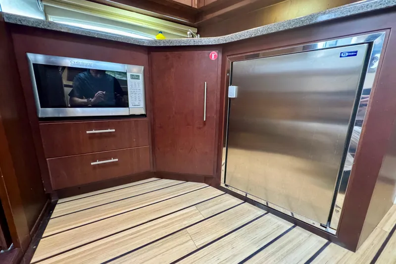 Knot Seine Yacht Photos Pics 2013 Regal 42 Sport Coupe kitchen with microwave and stainless steel fridge.