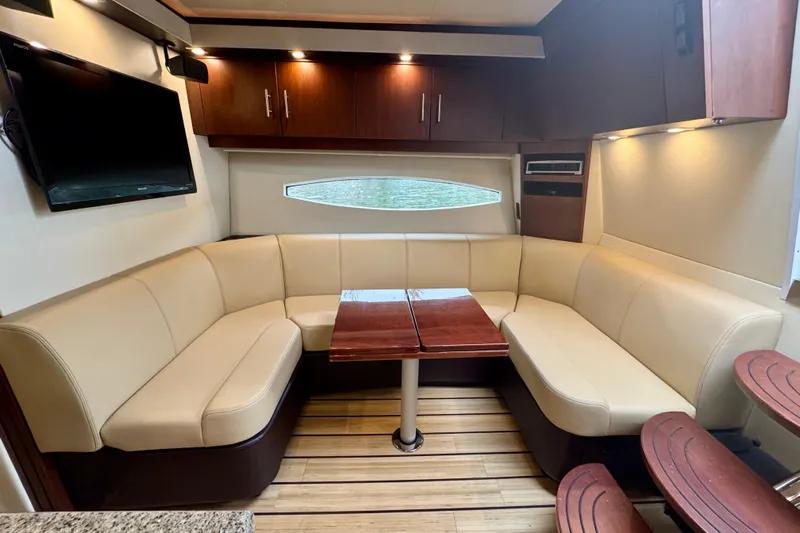 Knot Seine Yacht Photos Pics Luxurious interior of 2013 Regal 42 Sport Coupe with beige seating and wooden accents.