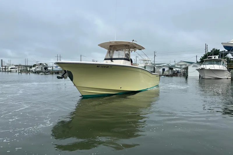  Yacht Photos Pics 2020 Grady-White Canyon 271 boat on calm water near a marina.