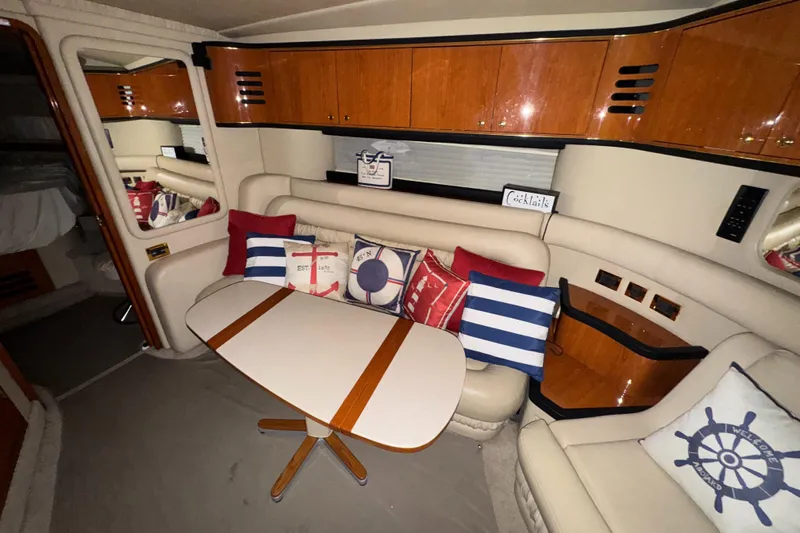 Kaboom Yacht Photos Pics Interior of 2000 Sea Ray 460 Sundancer with nautical-themed cushions and wooden cabinetry.