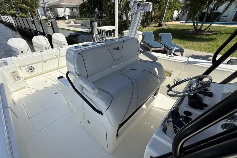 Seavee 37 Yacht Photos Pics 2021 SeaVee 37 boat interior with helm, seating, and Mercury engines docked by waterfront.
