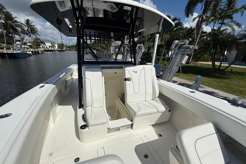 Seavee 37 Yacht Photos Pics 2021 SeaVee 37 boat interior with white seating, docked by a canal.