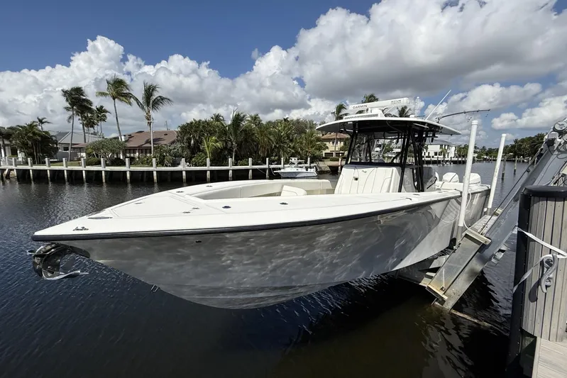 Seavee 37 Yacht Photos Pics 2021 SeaVee 37 boat docked by a scenic waterfront with palm trees.