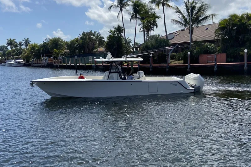 Seavee 37 Yacht Photos Pics 2021 SeaVee 37 boat cruising on a sunny day near palm-lined waterfront homes.