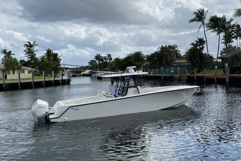 Seavee 37 Yacht Photos Pics 2021 SeaVee 37 boat cruising on a calm waterway with palm trees in the background.