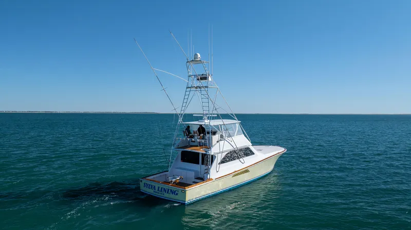 Sylva Lining Yacht Photos Pics 2001 Viking 61 Convertible yacht cruising on open sea under clear blue sky.