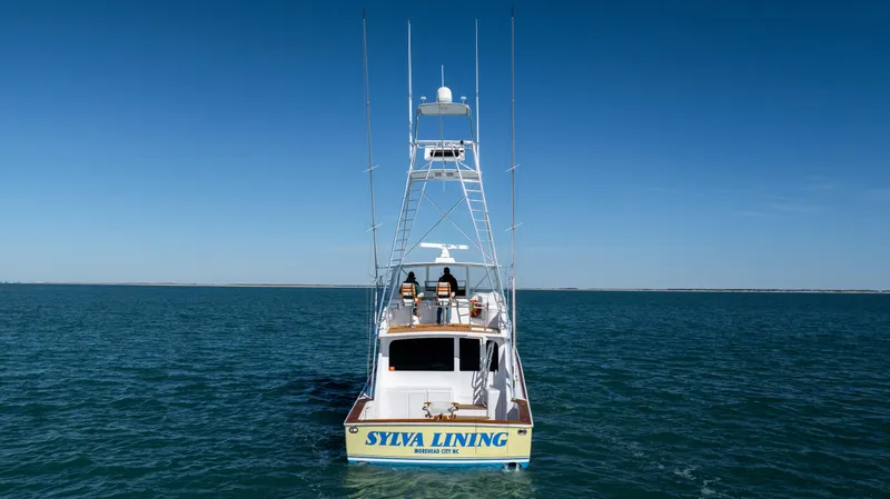 Sylva Lining Yacht Photos Pics 2001 Viking 61 Convertible boat on open water, rear view, clear blue sky.
