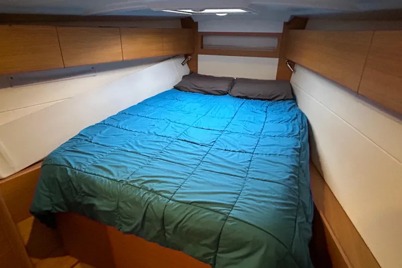 Xiomara Yacht Photos Pics Cozy cabin interior of 2019 X-Yachts X4&sup3; with blue bedding and wooden accents.