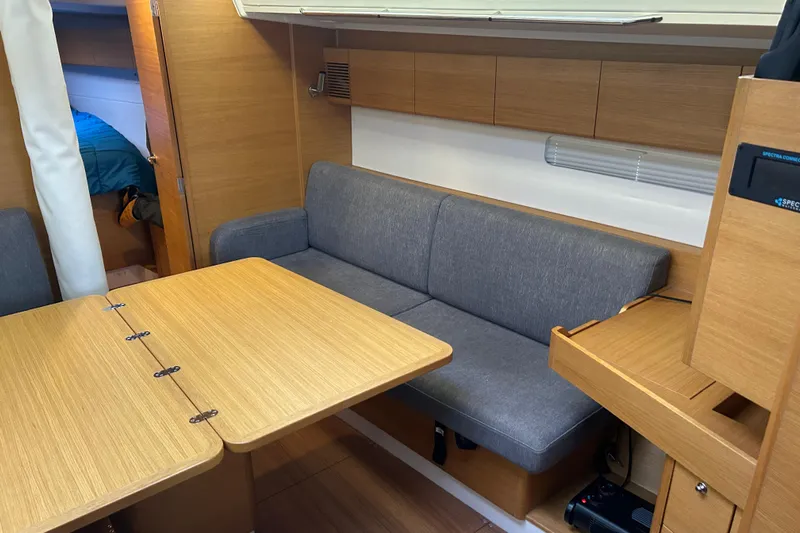 Xiomara Yacht Photos Pics Interior of 2019 X-Yachts X4&sup3; sailboat with wooden table and gray sofa.