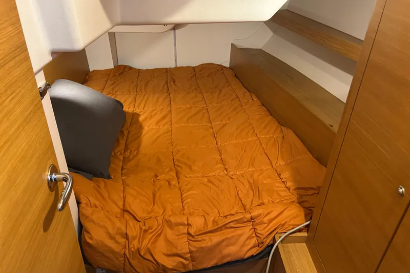 Xiomara Yacht Photos Pics Cozy cabin interior of 2019 X-Yachts X4&sup3; with orange bedding and wooden shelves.
