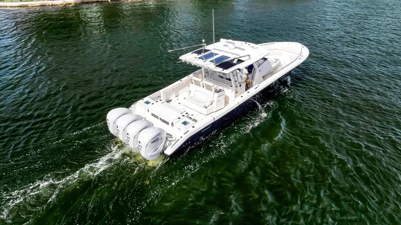 All Jack'd Up Yacht Photos Pics 2023 Pursuit S 428 Sport boat cruising on open water, rear view.