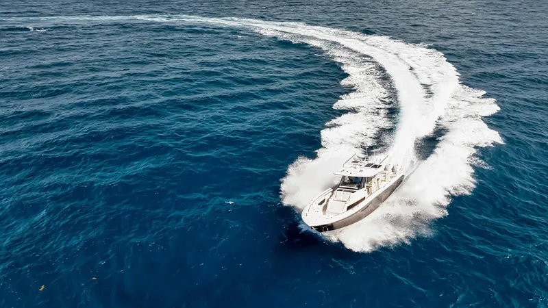 All Jack'd Up Yacht Photos Pics 2023 Pursuit S 428 Sport boat making a sharp turn on open ocean waters.