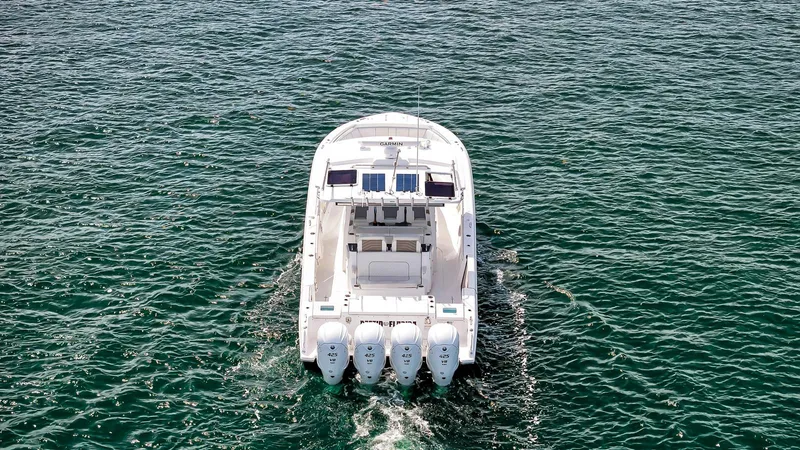 All Jack'd Up Yacht Photos Pics 2023 Pursuit S 428 Sport boat cruising on open water, rear view.