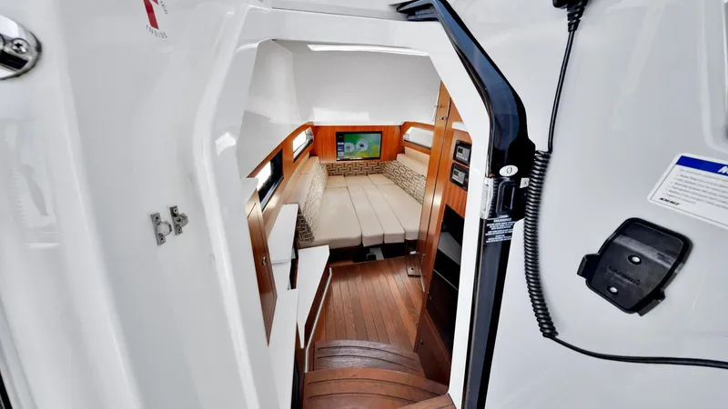 All Jack'd Up Yacht Photos Pics Interior cabin of 2023 Pursuit S 428 Sport boat with wood flooring and cozy seating.