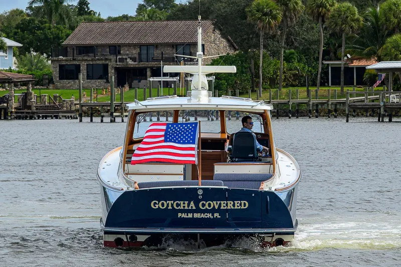 Gotcha Covered Yacht Photos Pics 2006 Hinckley Talaria 40 yacht cruising with American flag, Palm Beach backdrop.
