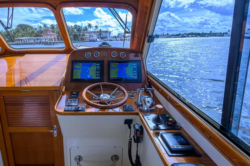 Gotcha Covered Yacht Photos Pics Helm of 2006 Hinckley Talaria 40 yacht with navigation screens and wooden steering wheel.