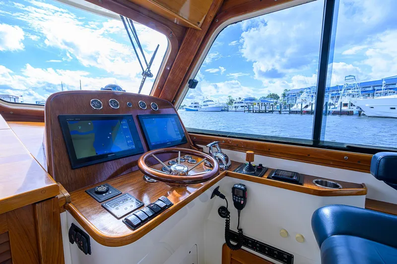 Gotcha Covered Yacht Photos Pics Helm of 2006 Hinckley Talaria 40 yacht with navigation screens and wooden steering wheel.