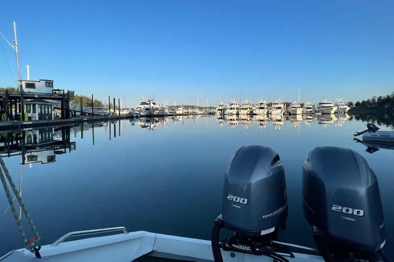  Yacht Photos Pics River Hawk SH Offshore XL 2015 boat with twin engines, docked in a serene marina.