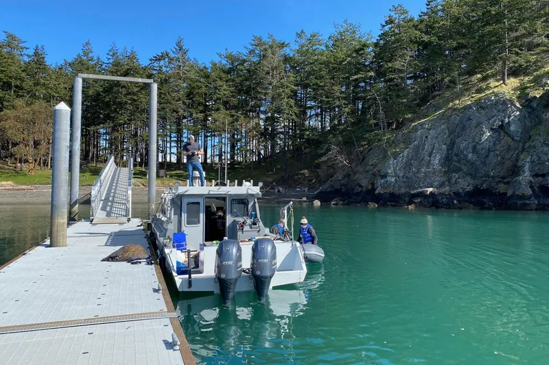  Yacht Photos Pics River Hawk SH Offshore XL 2015 boat docked in scenic forested bay.