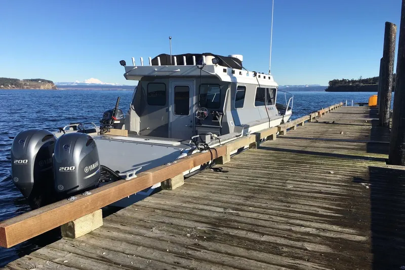  Yacht Photos Pics 2015 River Hawk SH Offshore XL boat docked at a wooden pier on a sunny day.
