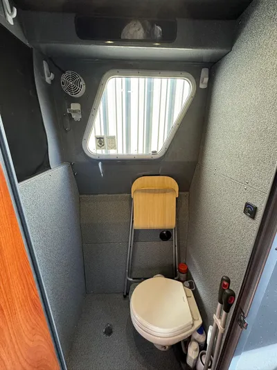  Yacht Photos Pics 2015 River Hawk SH Offshore XL boat bathroom with toilet, window, and folding seat.