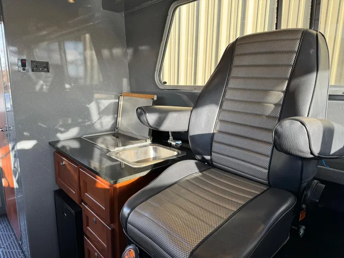  Yacht Photos Pics 2015 River Hawk SH Offshore XL interior with captain's chair and kitchenette.