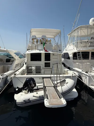  Yacht Photos Pics 1991 Bertram 43 Convertible yacht docked with inflatable boat attached.