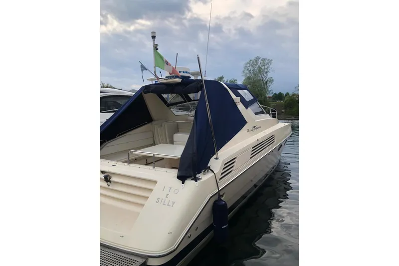  Yacht Photos Pics 1992 Riva TROPICANA 43 yacht docked, featuring blue canopy and flags.