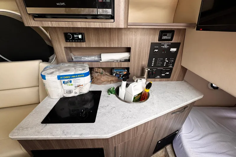  Yacht Photos Pics 2021 Regal 26 XO boat interior with kitchenette, control panel, and storage.