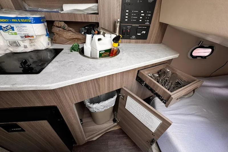  Yacht Photos Pics 2021 Regal 26 XO boat interior with kitchenette, utensils, and cleaning supplies.