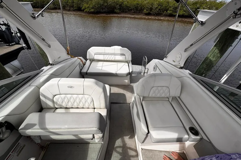 Yacht Photos Pics 2021 Regal 26 XO boat interior with white seating, docked by a calm river.