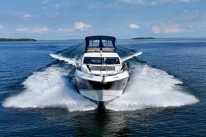 Why Not Yacht Photos Pics 2005 Sunseeker Manhattan 50 yacht cruising on open water, creating a dynamic wake.