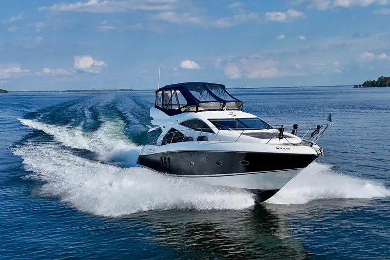 Why Not Yacht Photos Pics 2005 Sunseeker Manhattan 50 yacht cruising on open water under a clear blue sky.