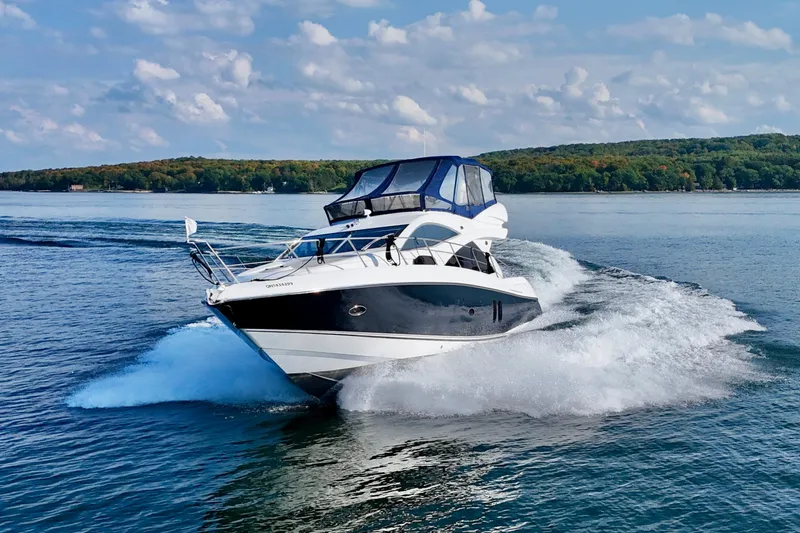 Why Not Yacht Photos Pics 2005 Sunseeker Manhattan 50 yacht cruising on a scenic lake under a blue sky.