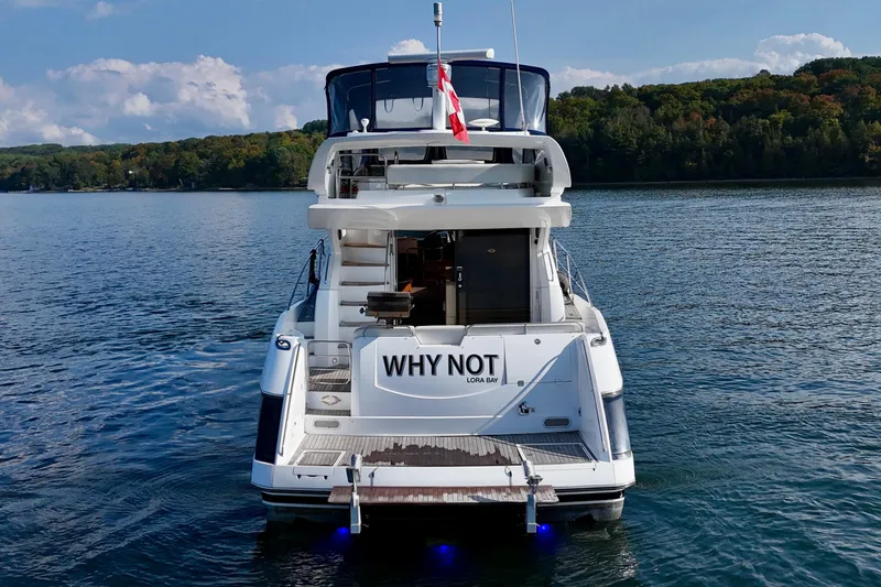 Why Not Yacht Photos Pics 2005 Sunseeker Manhattan 50 yacht on serene lake with lush forest backdrop.
