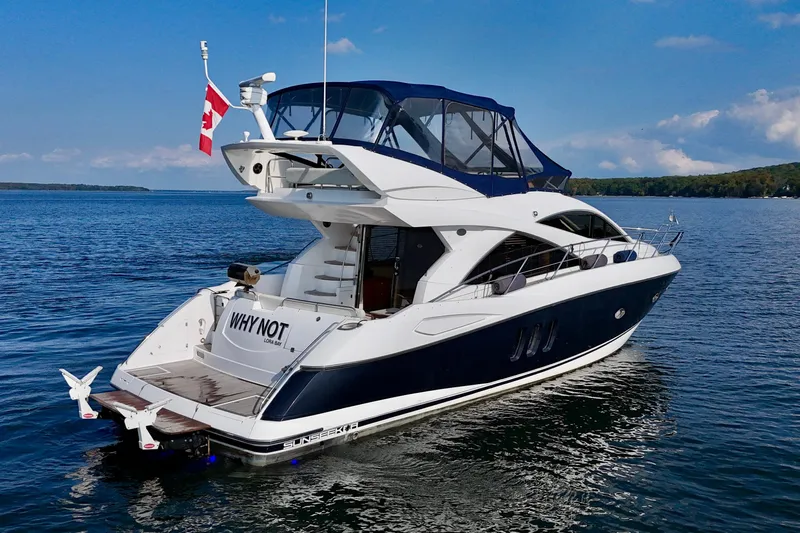Why Not Yacht Photos Pics 2005 Sunseeker Manhattan 50 yacht on calm water with Canadian flag.